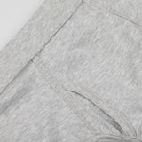 Close-up view of a light gray fabric detail with a curved seam and an attached pocket. The fabric, made from organic pima cotton, has a soft, heathered texture. This is part of the Grey Melange Pima Cotton Platan Briefs by The White Briefs.