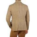 The back view of a man wearing a Beige Houndstooth Wool Tweed Vesuvio blazer by Tagliatore.