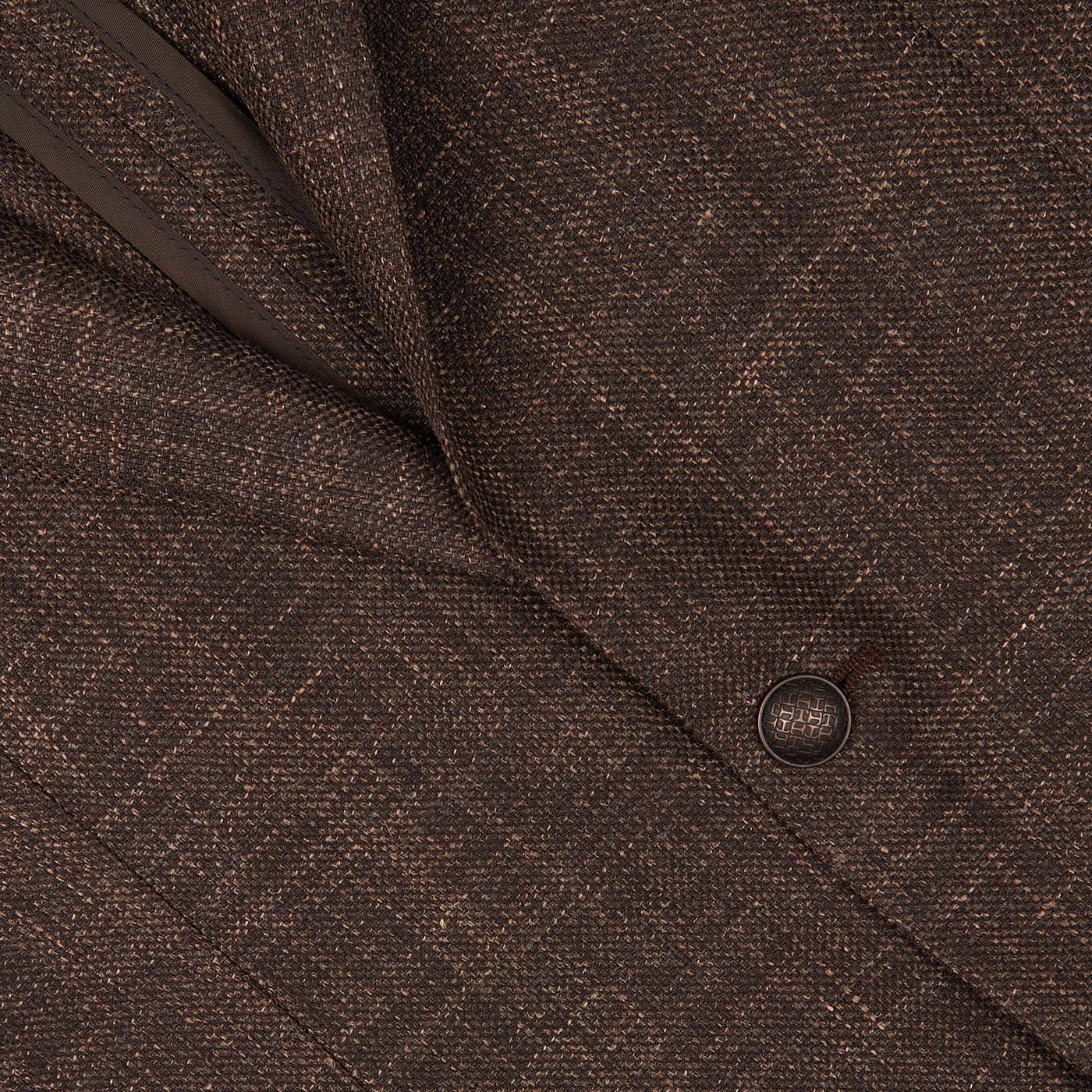 Close-up view of a textured fabric with a button on a Tagliatore Dark Brown Melange Wool Linen Silk Blazer, likely part of the Vesuvio model garment.
