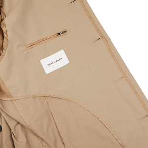 The Tagliatore Khaki Beige Cotton Nylon Trench Coat has a label on the back.