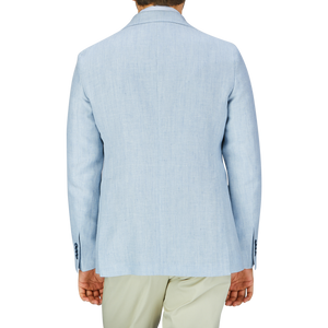 Man wearing a Tagliatore Light Blue Herringbone Linen Wool Vesuvio Blazer and pastel green pants, viewed from the back.