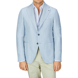 A man wearing a Tagliatore Light Blue Herringbone Linen Wool Vesuvio Blazer and cream trousers.