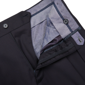A close up of the pocket of a high-waisted, black Tagliatore Midnight Navy Super 110s Wool Pleat Trousers.