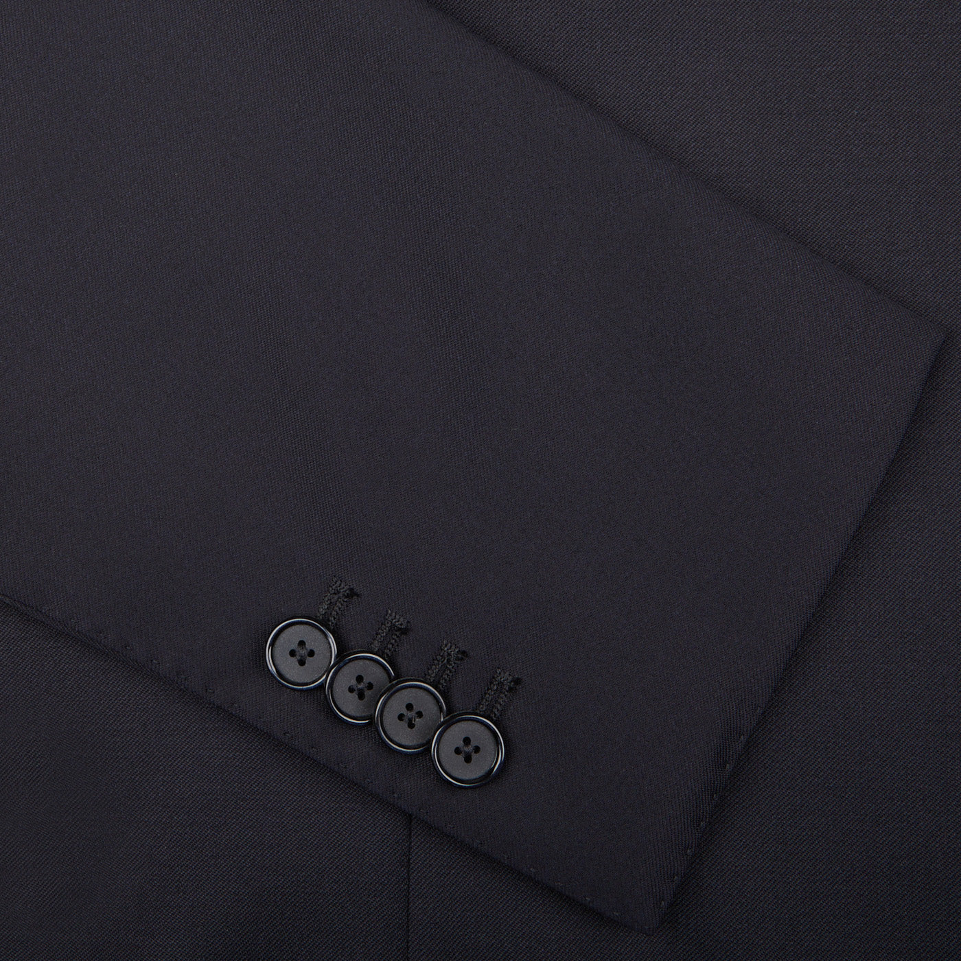 A Tagliatore Midnight Navy Super 110s Wool Suit Jacket, crafted from worsted semi-shiny 100% wool fabric, showcasing a stylish button detail.