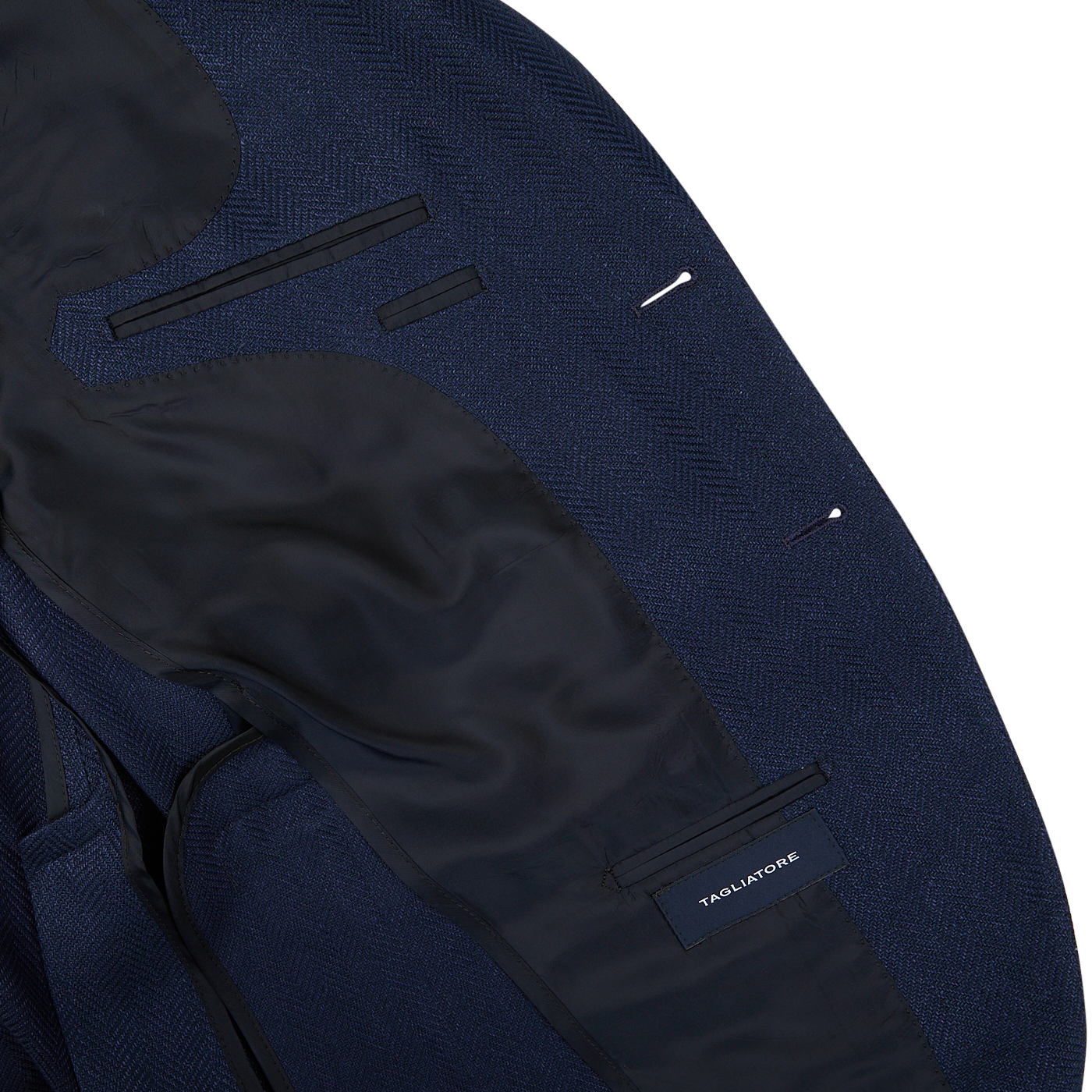 Close-up of a navy blue herringbone cotton linen Vesuvio blazer with black detailing, peak lapel, and a "Tagliatore" brand label.