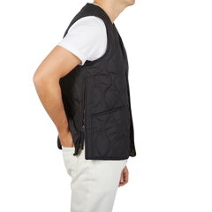 The back view of a man wearing a Taion Black Nylon Down V-Neck Button Vest filled with goose down.