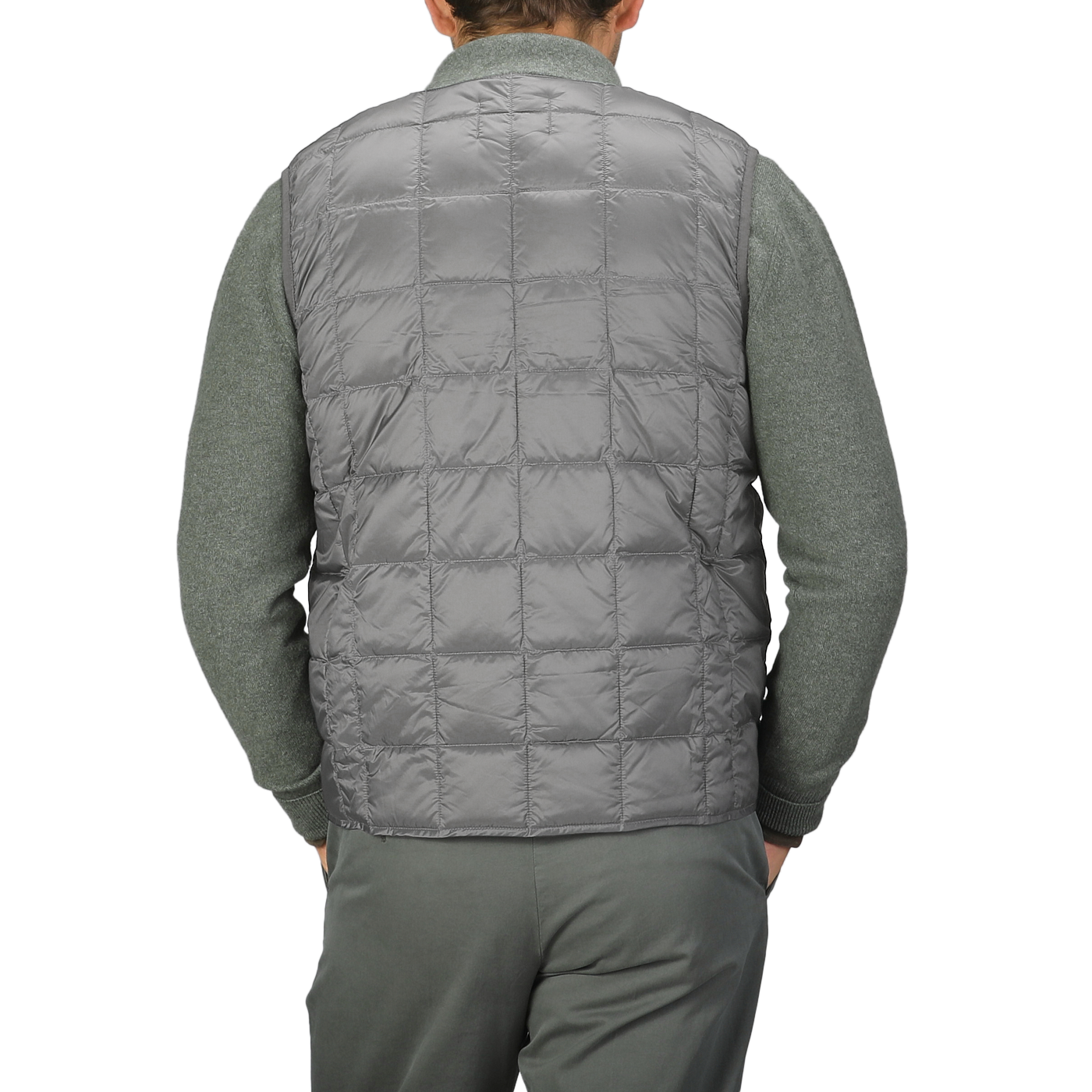 A person is seen from the back, dressed in a Charcoal Grey Nylon Down Padded Vest by Taion paired with matching gray pants.