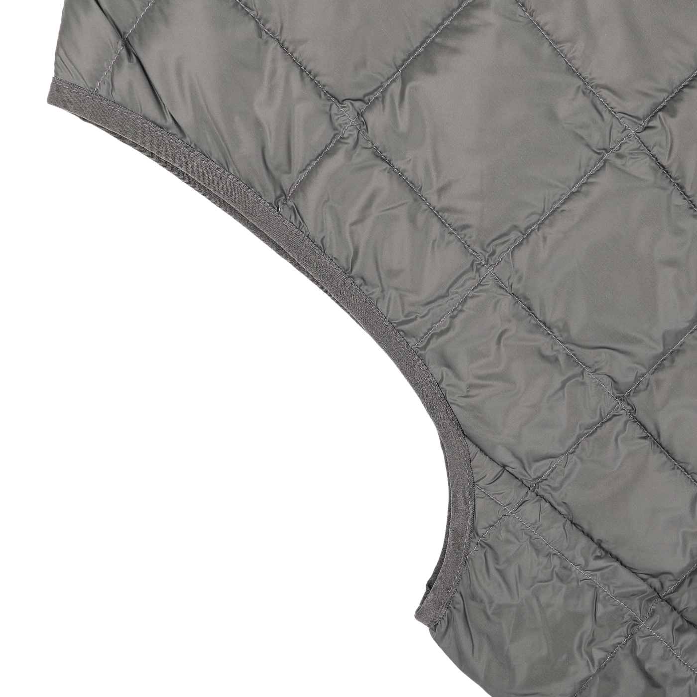 Close-up of a quilted fabric in charcoal grey nylon with visible stitching, reminiscent of a Taion Charcoal Grey Nylon Down Padded Vest, featuring a curved seam edge on the right side.