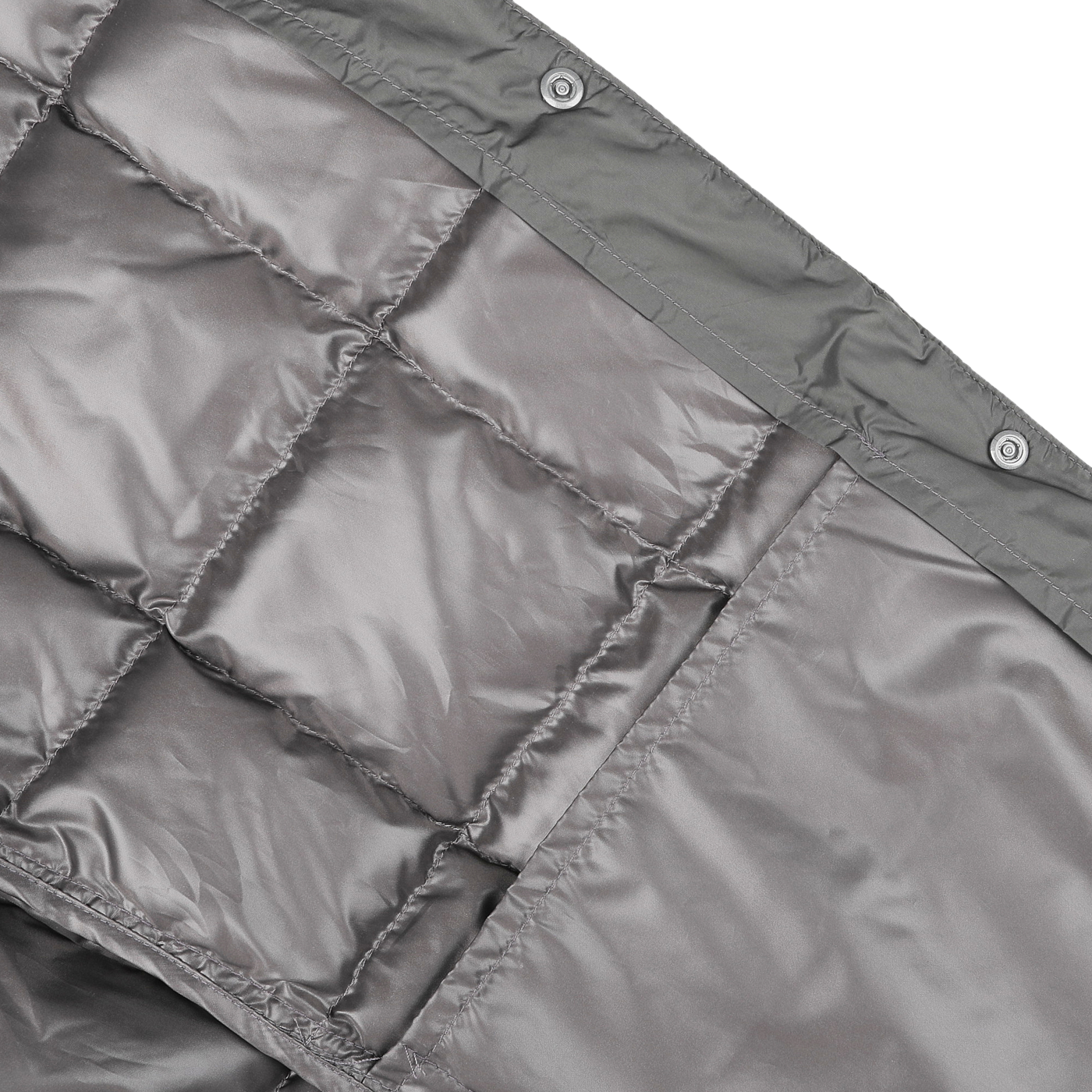 Close-up of a quilted charcoal grey fabric evoking the sleek design of Taion's Charcoal Grey Nylon Down Padded Vest, featuring squares and snap buttons along the edge.