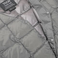 Close-up of the Taion Charcoal Grey Nylon Down Padded Vest, showcasing its quilted design with visible stitching and snap buttons for a stylish touch. The water-repellent fabric enhances practicality, and a label is attached to the collar for added detail.