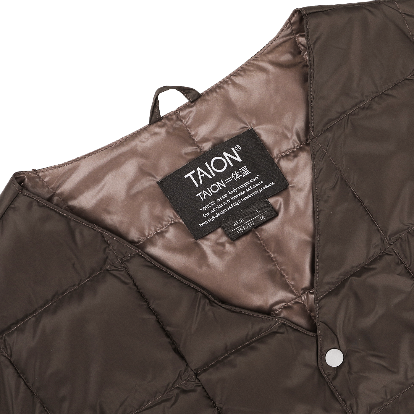 Close-up of a dark chocolate nylon down padded vest by Taion, featuring high-density nylon and goose down padding for warmth, with a visible label displaying the brand and size information.