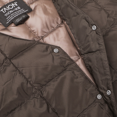 Close-up of the Dark Chocolate Nylon Down Padded Vest by Taion, showcasing a quilted design made from high-density nylon. Snap buttons add functionality, and a visible fabric label with the brand name "Taion" assures quality and style.