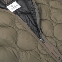 Close-up of a Dark Olive Nylon Down Padded Zip Vest by Taion, showcasing its high-density nylon construction with a partially open zipper that reveals a dark lining and care label.