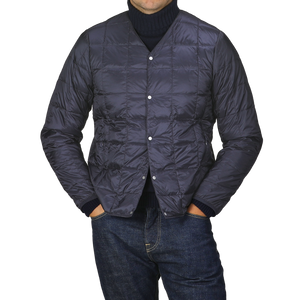 A person wearing the Navy Blue Nylon Down Padded Jacket by Taion, with arms relaxed, stands against a gray background.