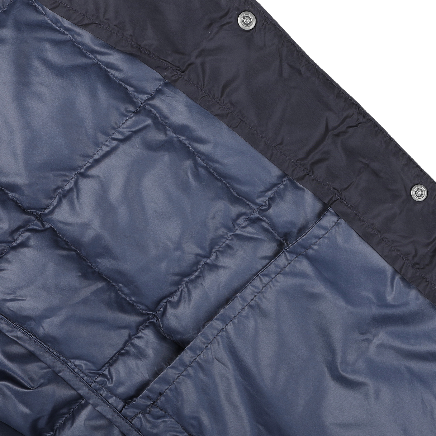 Close-up of the Navy Blue Nylon Down Padded Jacket by Taion, featuring high-density nylon and button details, resting on a lighter surface.