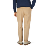 This is the back view of a man in Beige Cotton Linen Duilio Trousers from Tela Genova and a navy sweater.