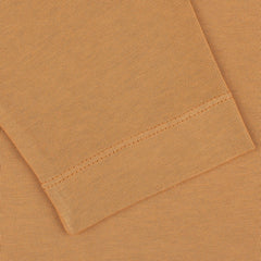 Close-up image of a folded, brick orange Tela Genova heavy organic cotton LS T-shirt with visible stitching details.