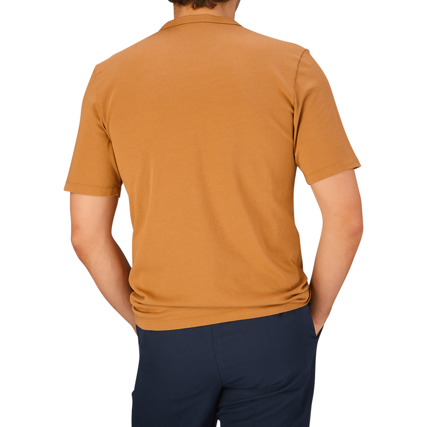A man wearing a Brick Orange Heavy Organic Cotton T-Shirt from Tela Genova and dark pants, viewed from behind.