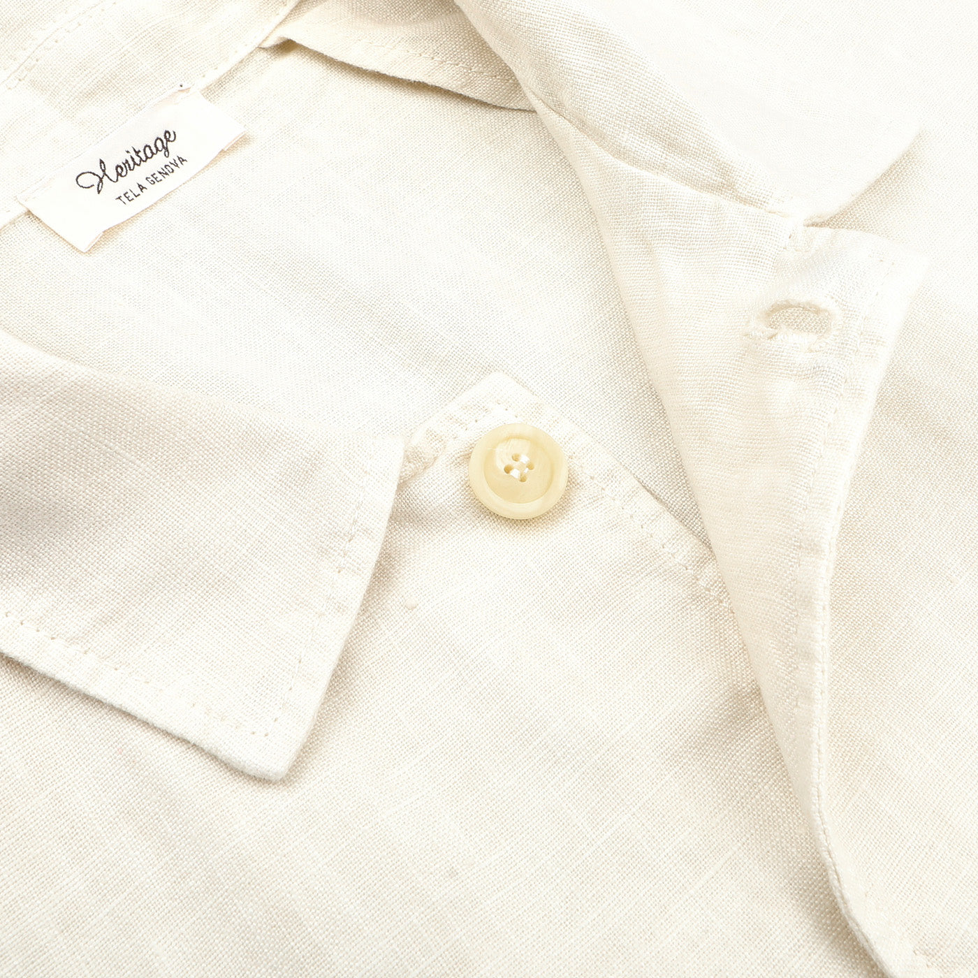 Close-up of an ecru pure linen Camillo jacket collar with a single button fastened, labeled "Tela Genova" and "Relaxed.