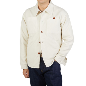 A man wearing a white Tela Genova Ecru White Brushed Cotton Leo Overshirt and jeans.