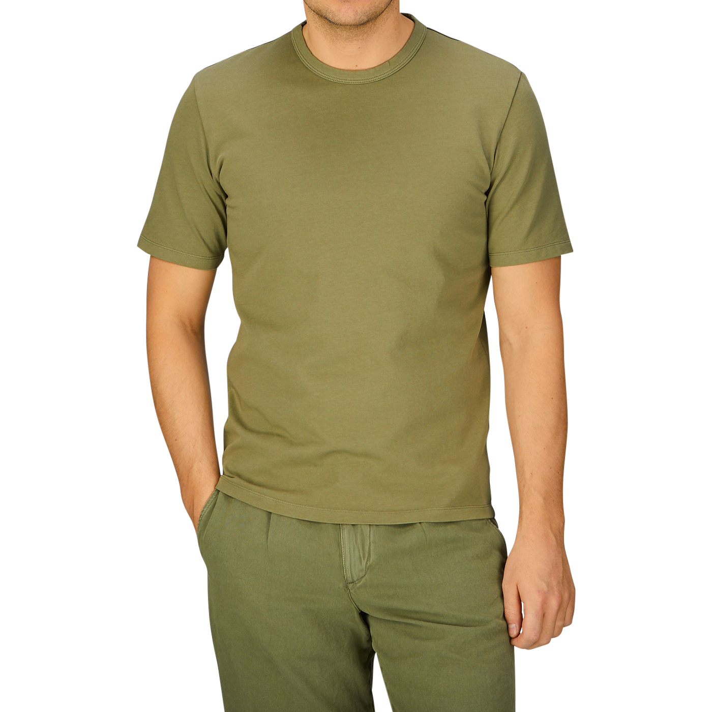 A person wearing a plain Olive Green Heavy Organic Cotton T-Shirt by Tela Genova and matching pants against a blue background.