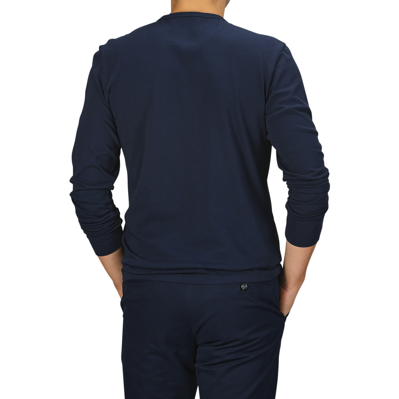 A person wearing a Tela Genova Navy Blue Heavy Organic Cotton LS T-Shirt and matching navy pants made from organic cotton stands with their back to the camera against a plain background.