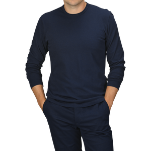 A person wearing a Navy Blue Heavy Organic Cotton LS T-Shirt by Tela Genova and matching pants stands with hands in their pockets against a plain background.