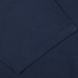 Folded navy blue heavy organic cotton T-shirt with visible stitching detail from the Italian brand, Tela Genova.