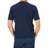 Rear view of a person wearing a Tela Genova navy blue heavy organic cotton t-shirt and pants.