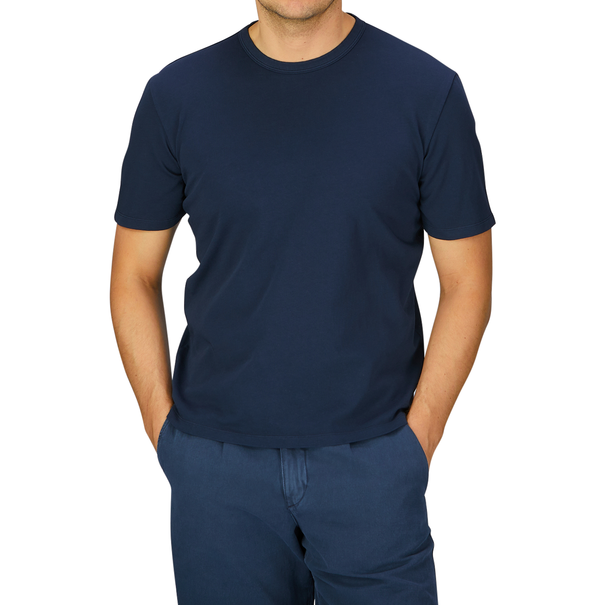 A man wearing a Navy Blue Heavy Organic Cotton T-Shirt by the Italian brand Tela Genova and blue pants standing against a grey background.