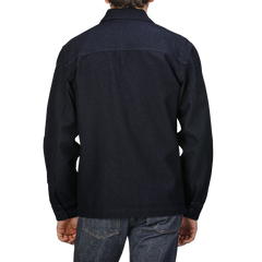 A person wearing a Navy Blue Wool Cotton Greto Overshirt by Tela Genova, paired with dark denim jeans, is shown from the back against a plain background, embodying a sophisticated casual look.