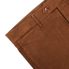 Close-up of Tela Genova's Tobacco Brown Cotton Moleskin Berardo Trousers, showcasing the button, belt loop, and front pocket against a white background.