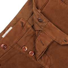 Close-up of Tela Genova's Tobacco Brown Cotton Moleskin Berardo Trousers, featuring a button fly detail that highlights the precise stitching and buttonholes. These trousers are crafted from cotton moleskin for a refined touch and exceptional durability.