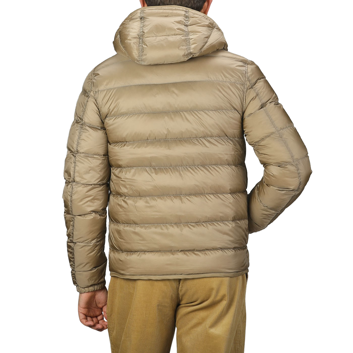 A person wearing a Ten C Beige Nylon Down Padded Liner Hood Jacket, viewed from the back. This technical outerwear features premium goose down insulation, ensuring warmth and comfort in colder conditions.