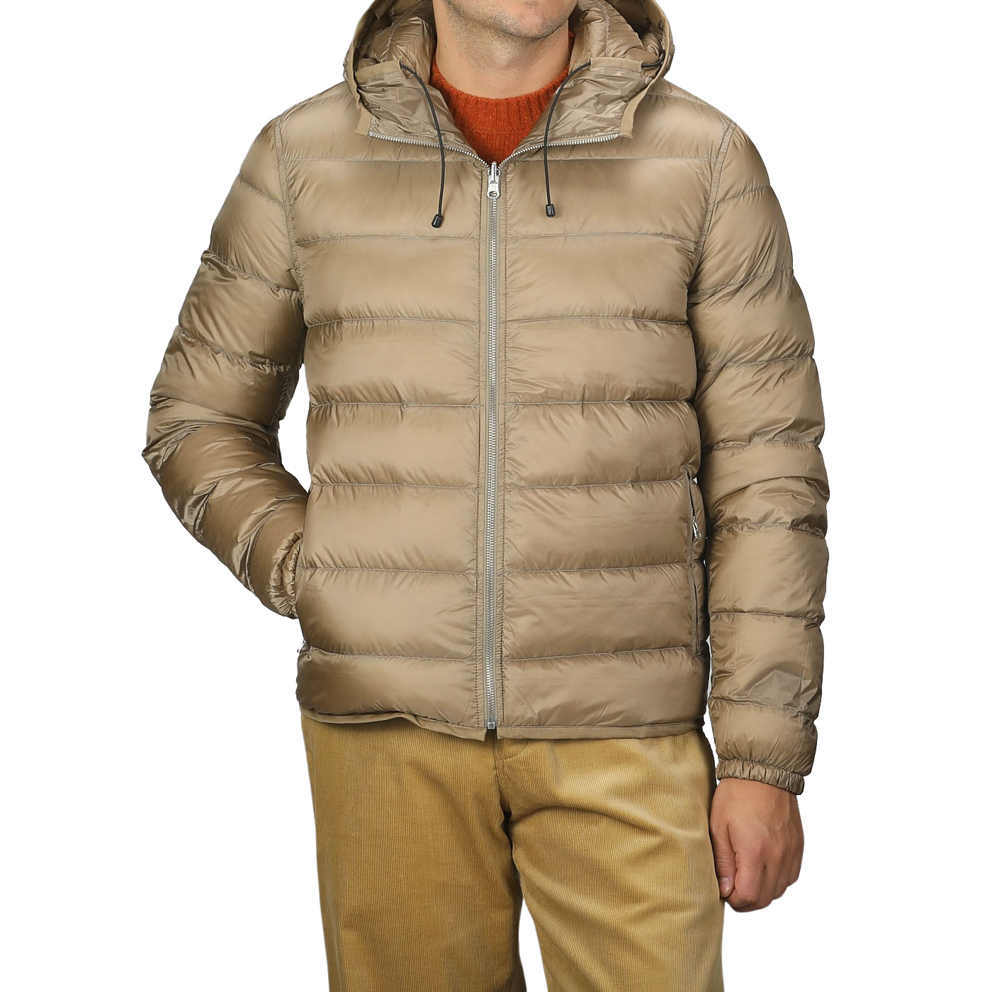 A person wearing a Ten C Beige Nylon Down Padded Liner Hood Jacket with a visible front zipper and their hands in the pockets. The jacket is paired with mustard-colored pants and a burnt orange sweater underneath.