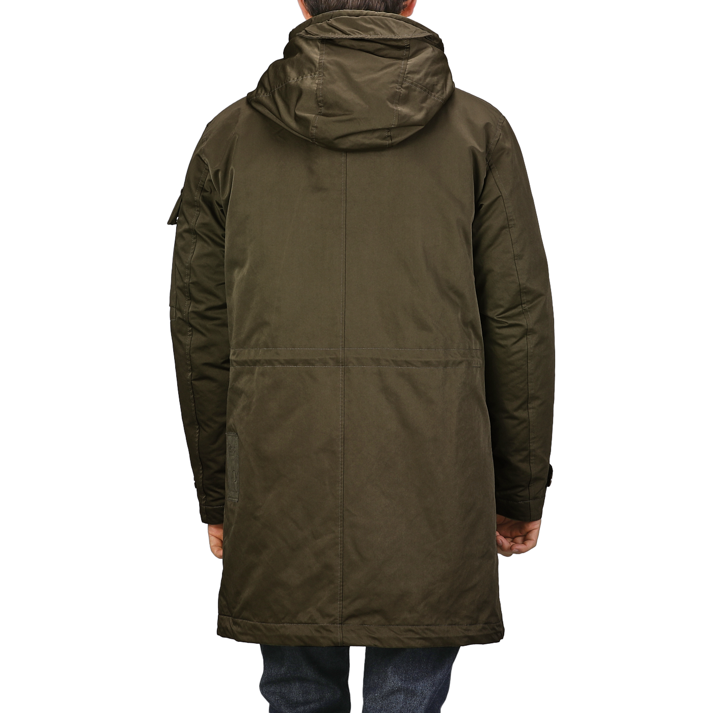 The image features the back view of a person wearing a Ten C Green Technical Rainstorm Parka, made from waxed material, paired with blue jeans against a plain background.