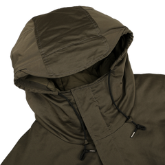 The Green Technical Rainstorm Parka by Ten C is crafted from waxed material, featuring adjustable black drawstrings on a white background.