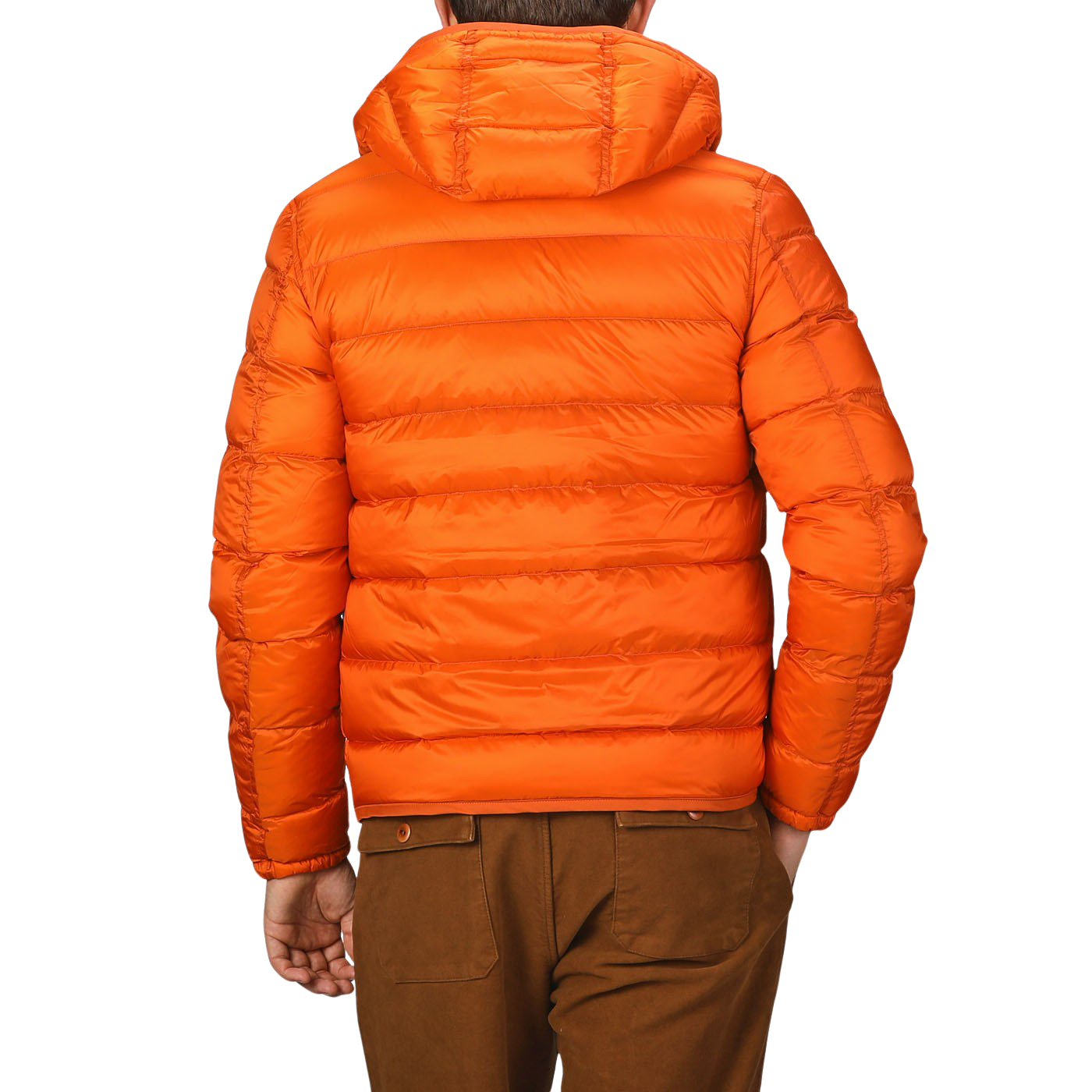 A person wearing the Ten C Orange Nylon Down Padded Liner Hood Jacket and brown pants is shown from the back, the technical outer nylon and goose down padding providing both warmth and durability.