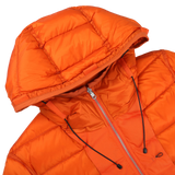 Close-up of the "Orange Nylon Down Padded Liner Hood Jacket" by Ten C. This technical outer nylon jacket features a front zipper, black drawstrings on the hood, and goose down padding for ultimate warmth.