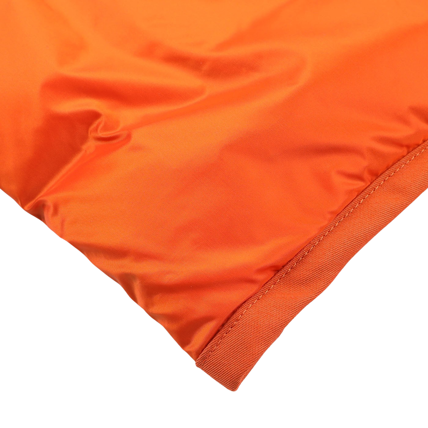 Close-up image of an Orange Nylon Down Padded Liner Hood Jacket by Ten C, showcasing a corner with visible stitching and a smooth, shiny texture, reminiscent of high-quality goose down padding in a technical outer nylon jacket.