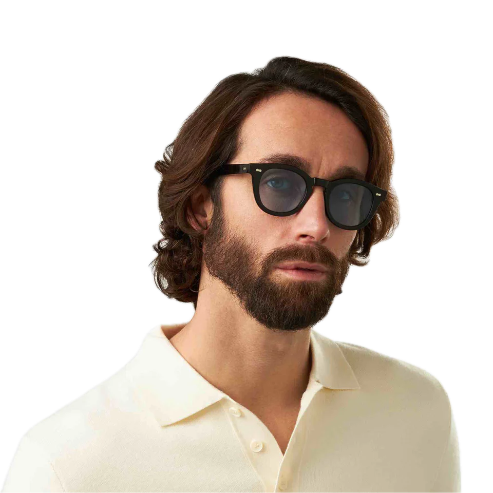 Man with shoulder-length curly hair wearing sunglasses and a cream shirt from The Bespoke Dudes.