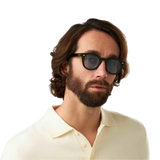 Man with shoulder-length curly hair wearing sunglasses and a cream shirt from The Bespoke Dudes.