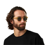 Man with long curly hair wearing The Bespoke Dudes Twill Matte Champagne Green Lenses 49mm sunglasses and a black shirt.
