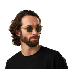 Man with long curly hair wearing The Bespoke Dudes Twill Matte Champagne Green Lenses 49mm sunglasses and a black shirt.