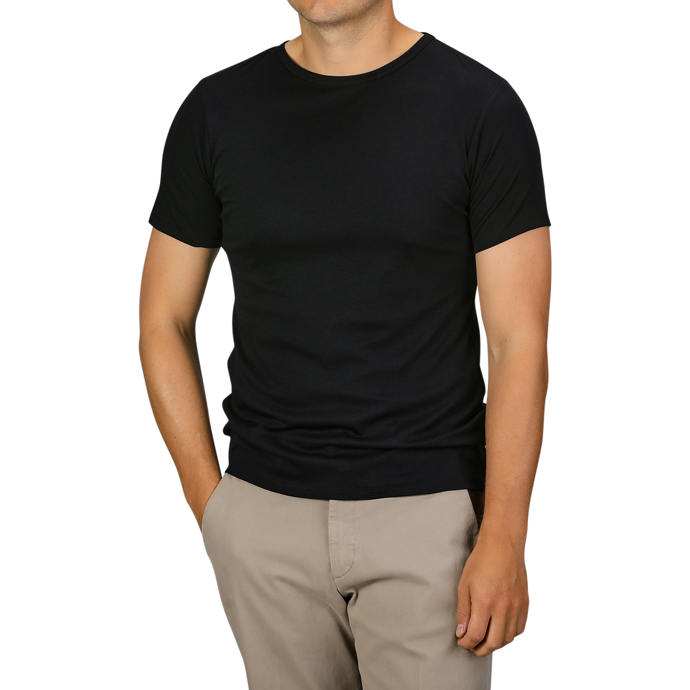 A person is standing, wearing a Black Pima Cotton Earth T-Shirt from The White Briefs and beige pants, with their hands resting in their pockets.