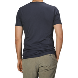 A person wearing The White Briefs' Parisian Night Pima Cotton Earth T-Shirt in dark gray and light gray pants is seen from behind against a plain background.