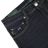 Close-up of the waistband and front pocket of Tramarossa's Dark Blue Cotton Cashmere Michelangelo Jeans, featuring green stitching and custom initials "Q B" on a black tag, showcasing comfort stretch denim for ultimate wearability.