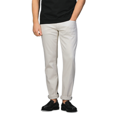 A person wearing a black shirt, Tramarossa Off White Super Stretch Michelangelo Jeans, and black shoes stands against a plain background.