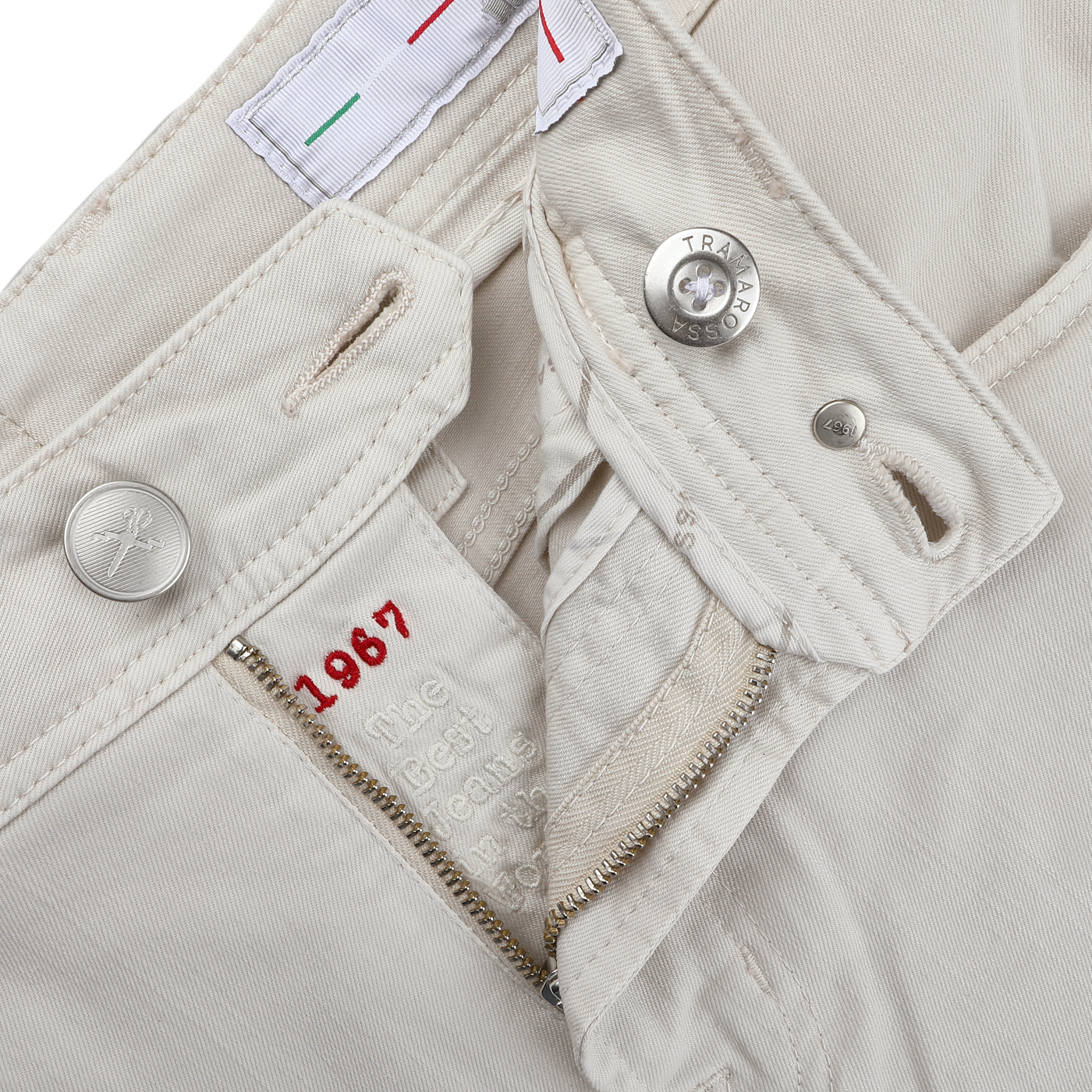 Tramarossa's Off White Super Stretch Michelangelo Jeans feature a cream tone with an unzipped fly, metal button, red "1967" text inside, and an Italian flag detail on the inner waistband near a buttonhole for style.