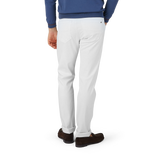 A man in White Super Stretch Michelangelo Jeans and a blue sweater by Tramarossa.